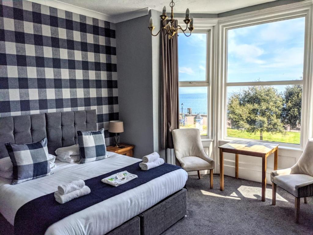 a bedroom with a bed and a large window at The Wildings Hotel & Tudno's Restaurant in Llandudno