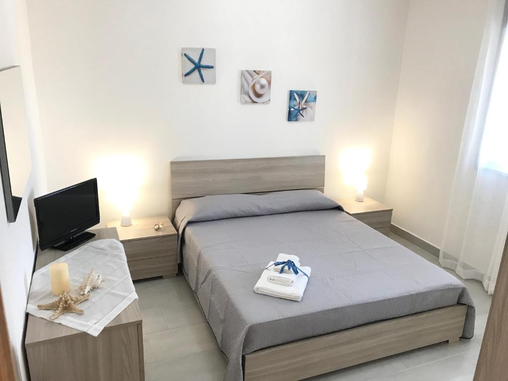 niewielka sypialnia z łóżkiem i telewizorem w obiekcie Villa RaFà w mieście Avola