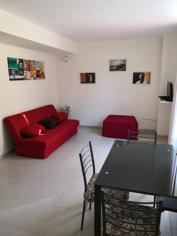 un soggiorno con un divano rosso e un tavolo di Guest House Milva a Sperlonga
