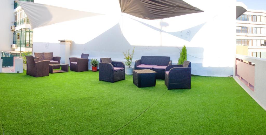 a group of chairs and tables on a green lawn at Alagoa Terrace Guesthouse in Faro