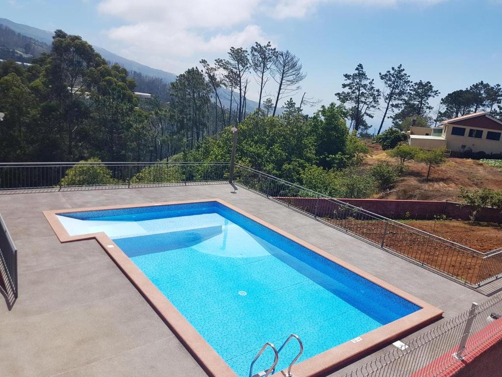 a swimming pool on top of a house at Charming Apartment in Prazeres with Shared Pool - 150 m² in Campanário