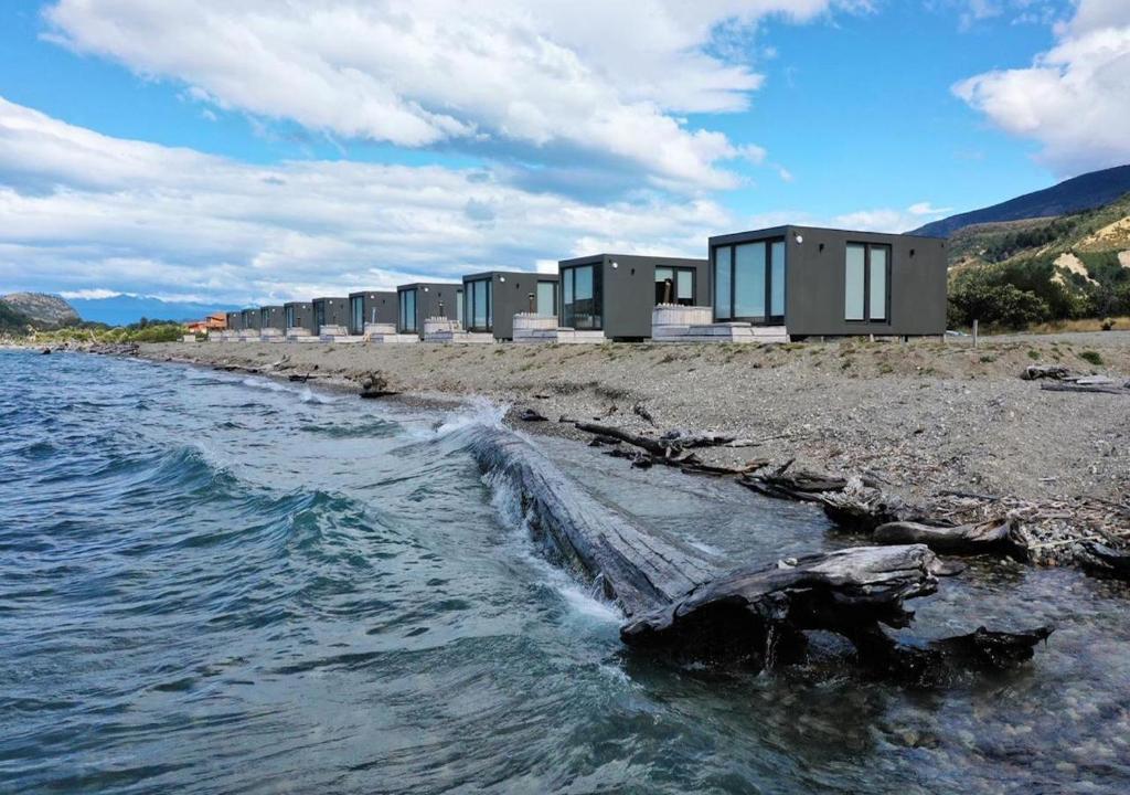 a row of houses on the shore of a body of water at Chelenko Lodge in Puerto Tranquilo