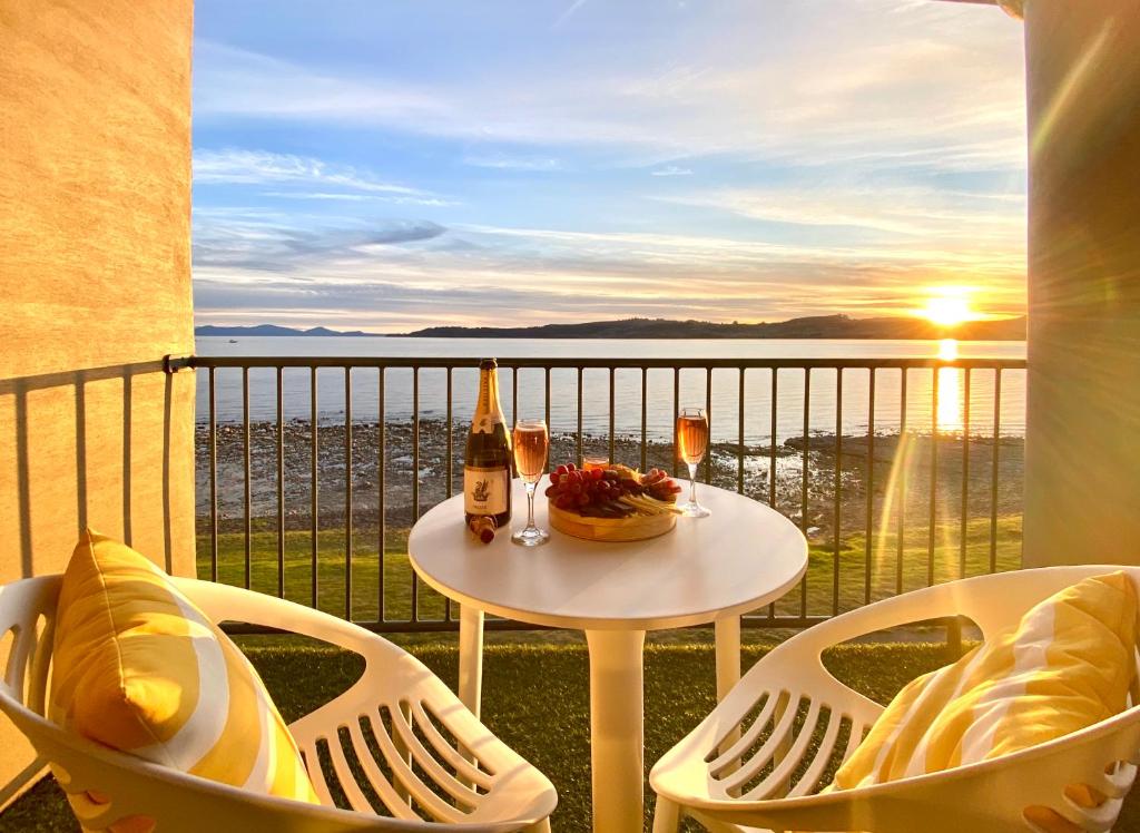 einen Tisch und Stühle auf einem Balkon mit Meerblick in der Unterkunft Boulevard Waters in Taupo