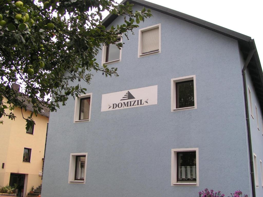 ein blaues Gebäude mit einem Schild an der Seite in der Unterkunft Domizil in Moosbach
