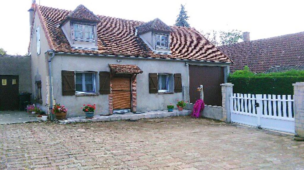 ein Haus mit einem weißen Zaun und einer steinernen Einfahrt in der Unterkunft Maison d'une chambre avec wifi a Saint Pere in Saint-Père
