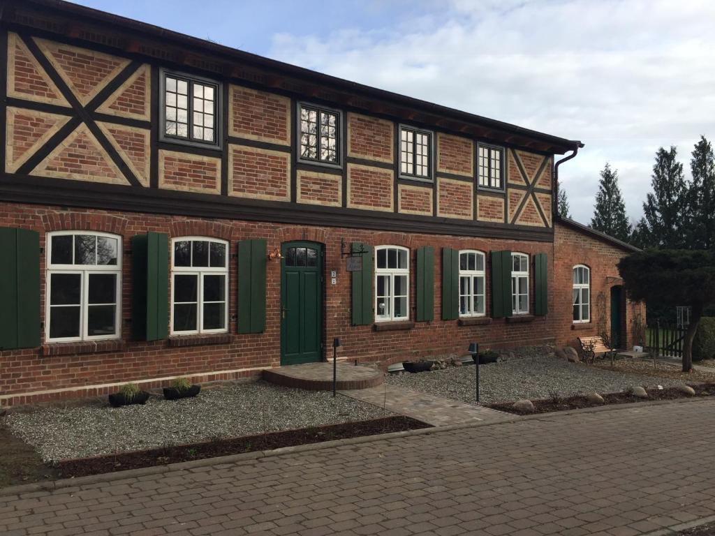 a large brick building with green doors and windows at Alte Küsterei Hohen Mistorf in Hohen Mistorf