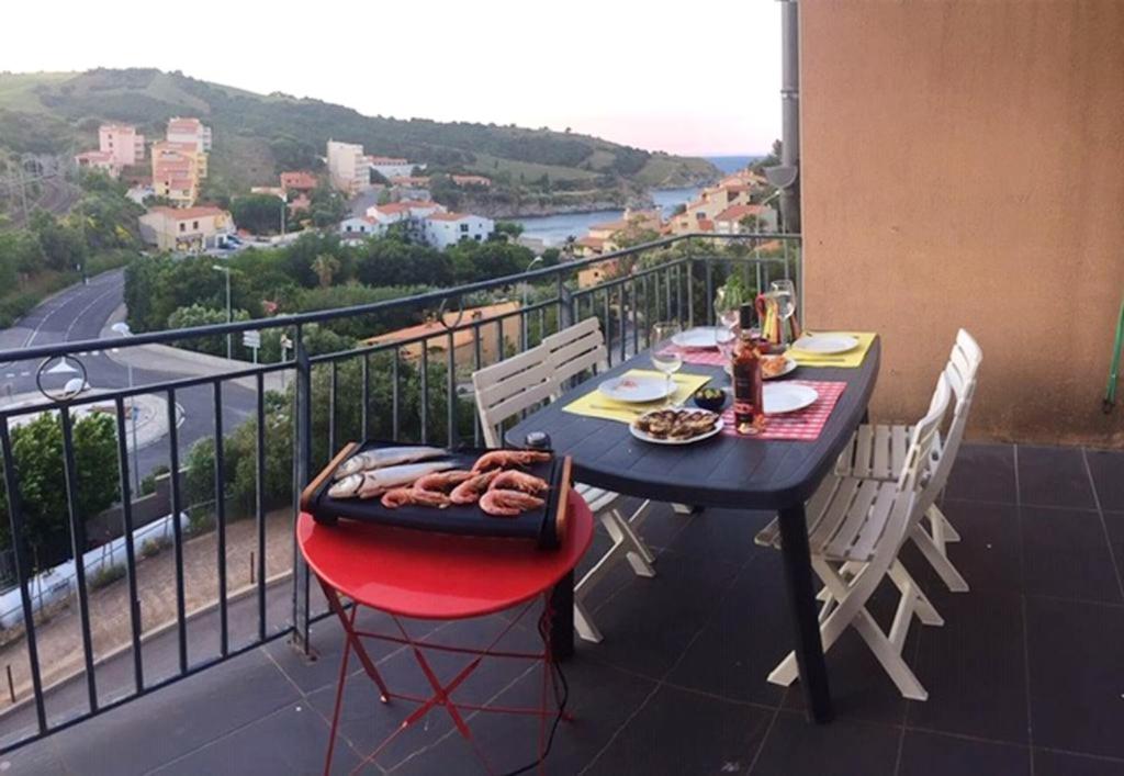 un tavolo con vassoio di cibo sul balcone di Appartement panoramique à Banyuls-sur-Mer, vue mer et montagne a Banyuls-sur-Mer