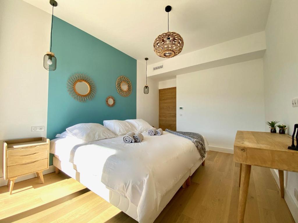 a bedroom with a large bed with a blue wall at Villas de standing avec magnifique vue mer et piscines privées, Sagone in Sagone