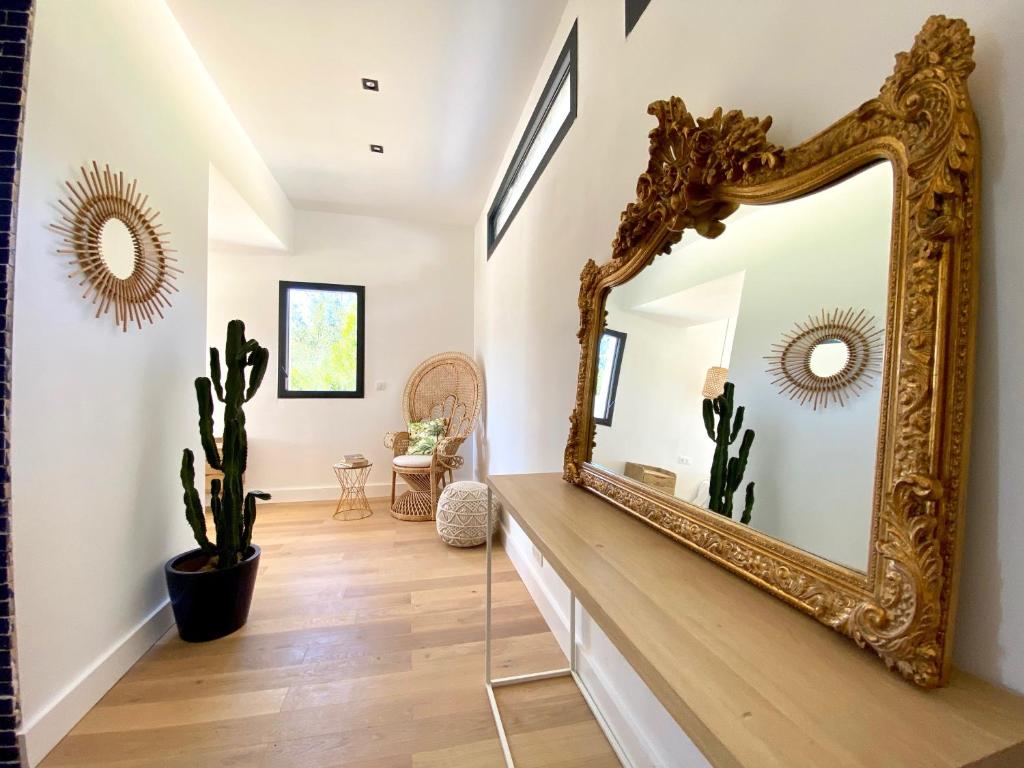 an ornate gold mirror on a wall in a hallway with a cactus at Villas de standing avec magnifique vue mer et piscines privées, Sagone in Sagone