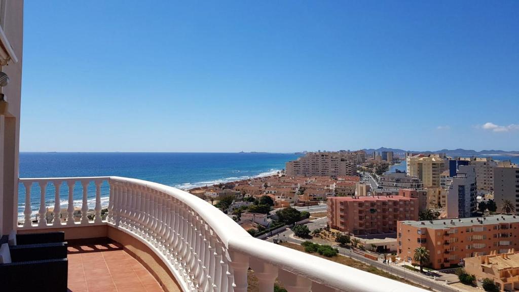 ラ・マンガ・デル・マール・メノールにある2 bedrooms appartement at La Manga 100 m away from the beach with sea view furnished terrace and wifiの市街と海の景色を望むバルコニー