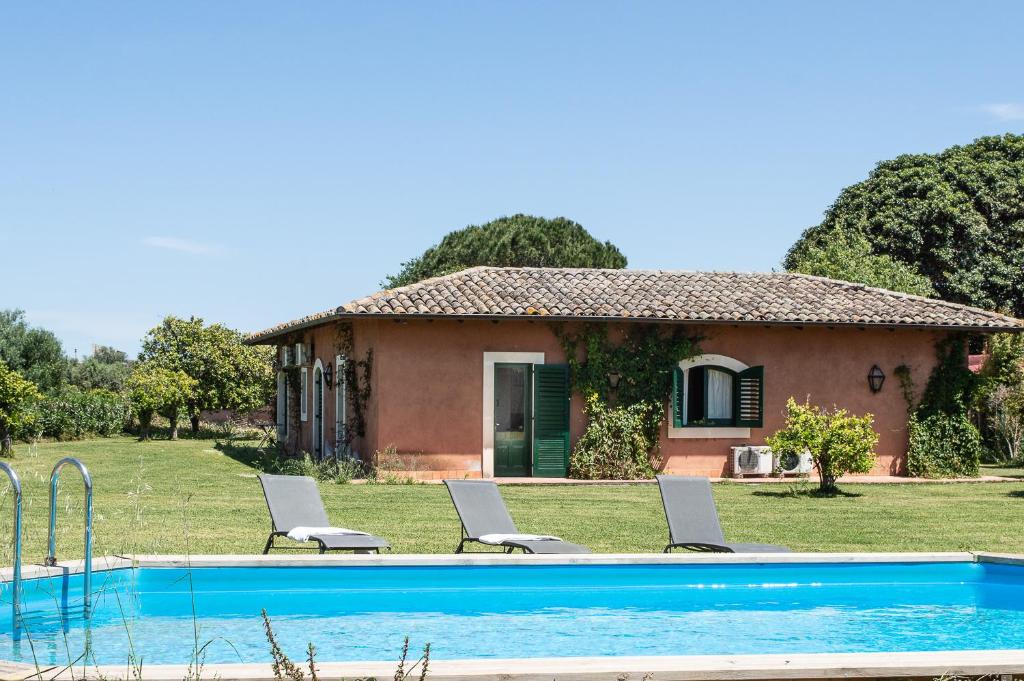 a house with a swimming pool in front of a house at Tenuta San Calogero Appartamento Salvia in Agnone Bagni
