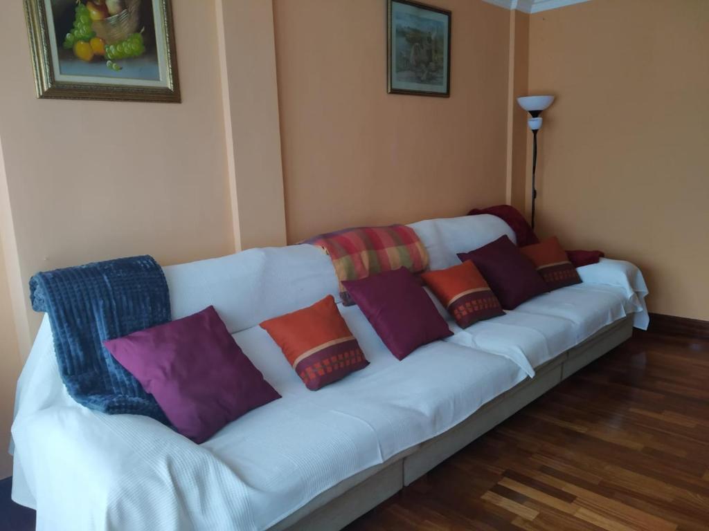 een witte bank met kleurrijke kussens erop bij Apartamento Trapagaran in Trapagaran