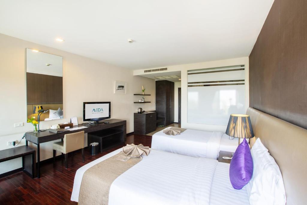 A twin room with a separate-looking desk, television console and entry area.