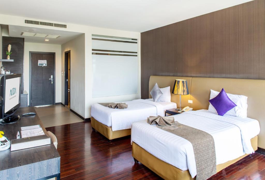 A twin room viewed from the desk, showing two beds, the entrance and built-in storage.