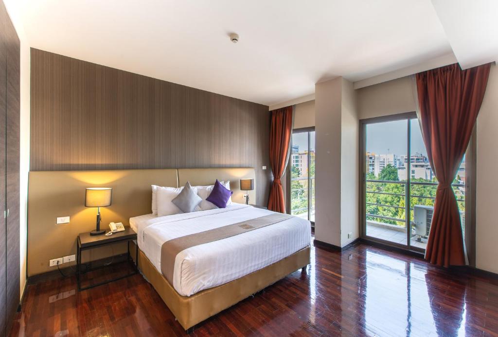 a bedroom with a large bed and a large window at Mida Hotel Don Mueang Airport in Bangkok