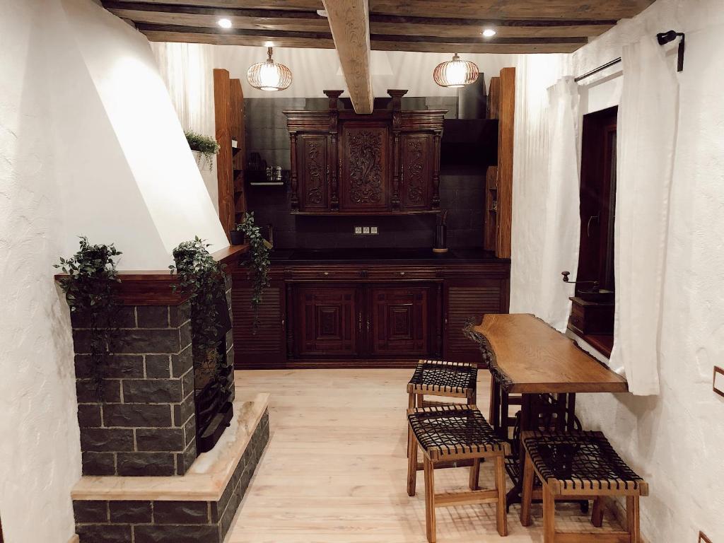 Zimmer mit einem Tisch, Stühlen und einem Kamin in der Unterkunft Clockhouse Cottage in Saulkrasti