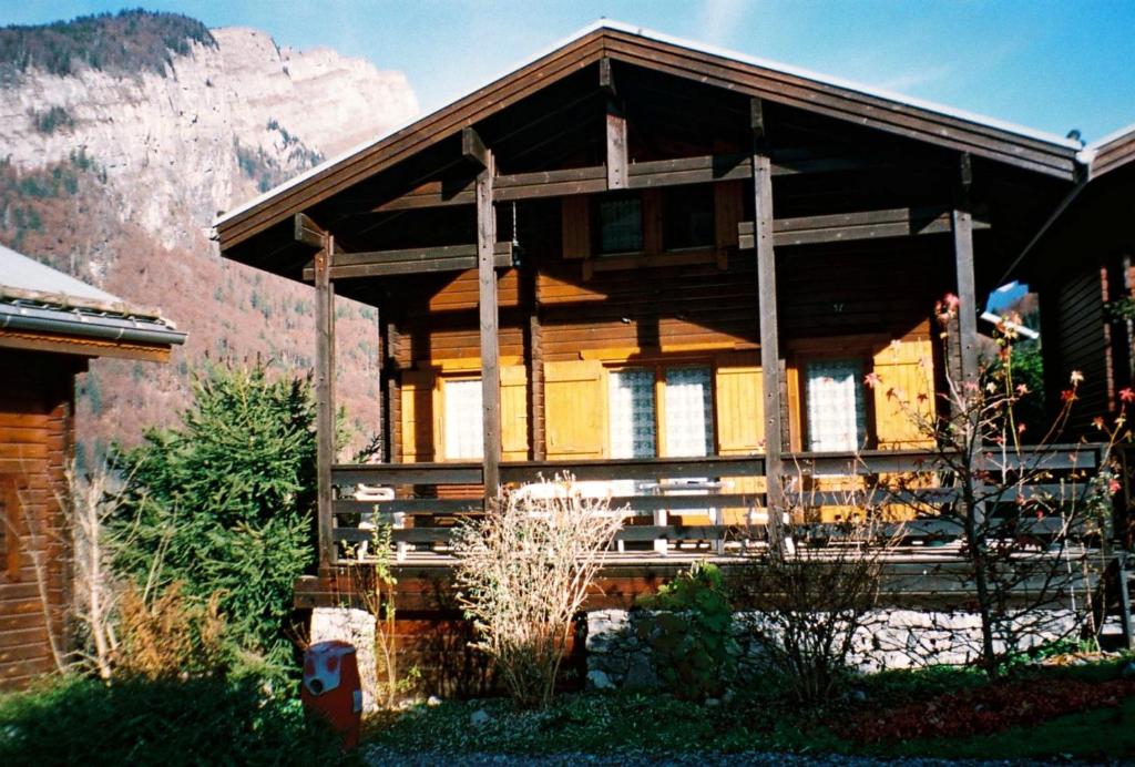 una casa de madera con una montaña en el fondo en Chalet de 2 chambres avec terrasse amenagee a Sixt Fer a Cheval en Sixt