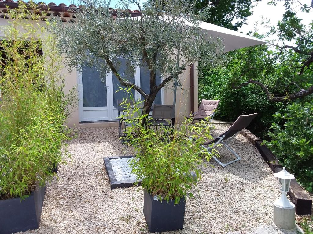 un giardino con tavolo, sedie e un albero di Au pays de la lavande... a Valensole