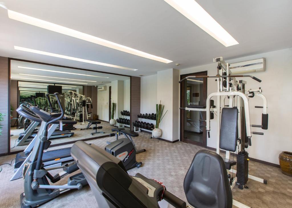 A bright fitness room with treadmills, cardio machines, free weights and a multi-station trainer.