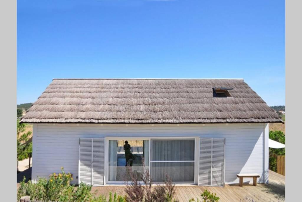 a person standing in a window of a house at Precious Cabin in Comporta in Comporta