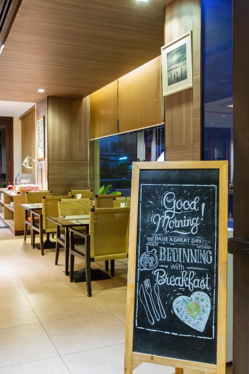 A breakfast dining area with woven chairs and a prominent welcome board.