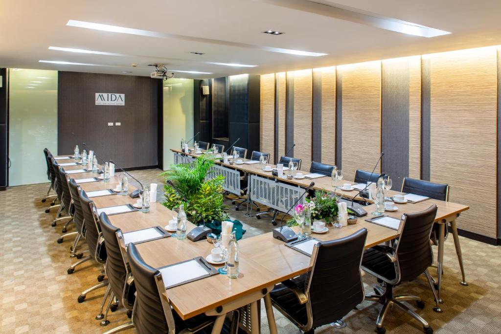 A boardroom with a long conference table, office chairs, place settings and presentation equipment.