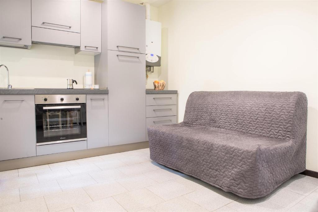 a kitchen with a chair in the middle of a room at Centro Storico Oltretorrente Apartment in Parma