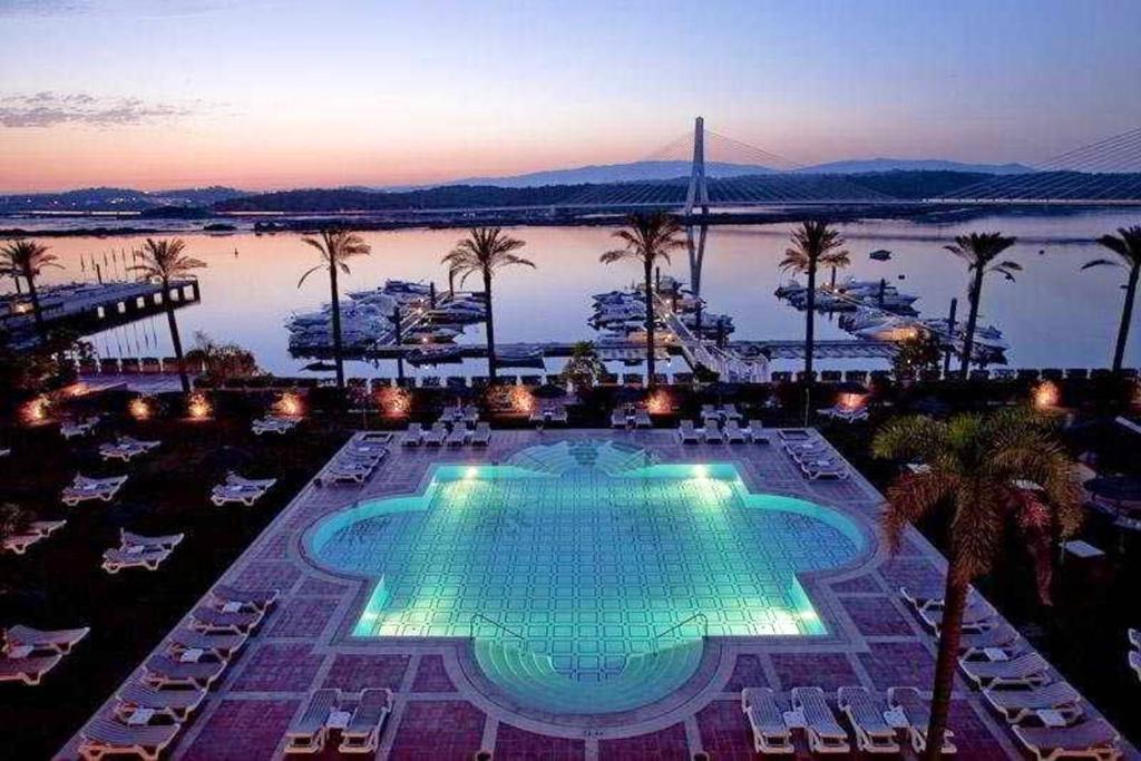 a large swimming pool with a view of the water at Charming Apartment in Estômbar with Private Pool. in Estômbar