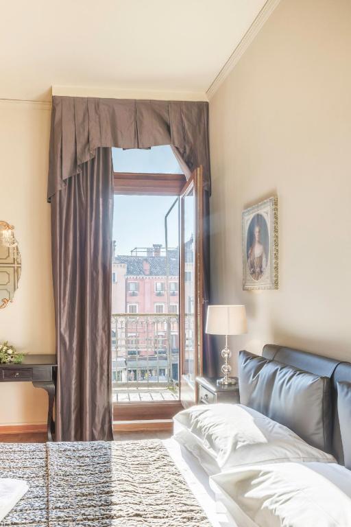 A bed or beds in a room at Rialto Canal View With Terrace and Balcony by Wonderful Italy