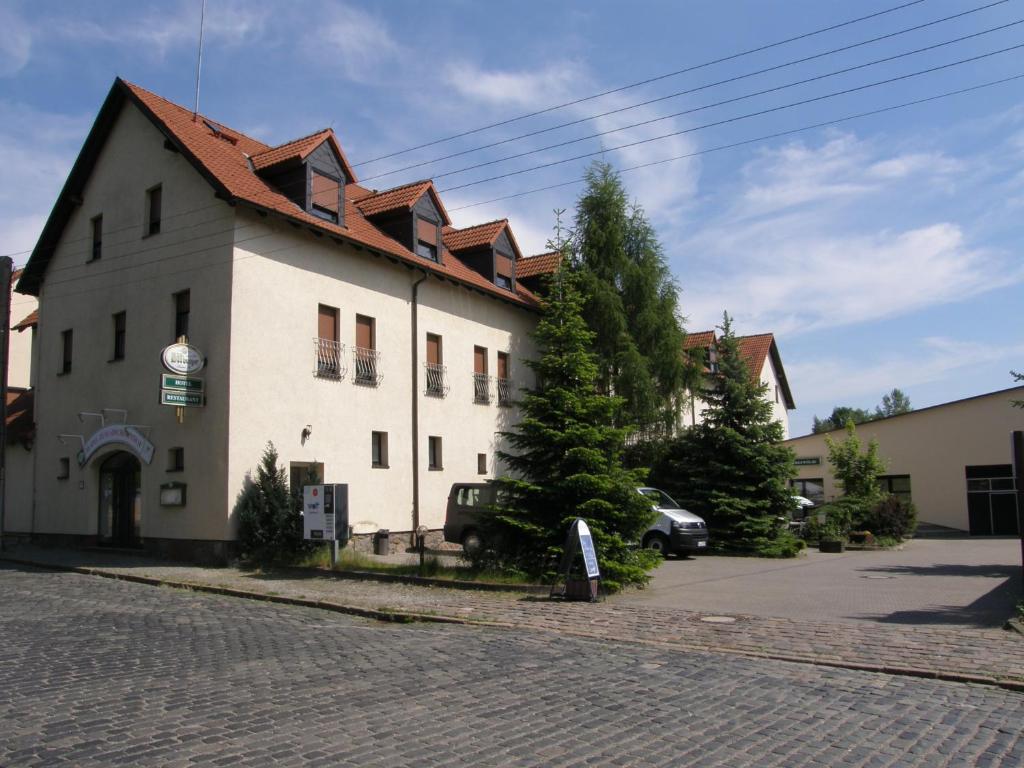 a white building with a red roof on a street at Hotel Zum Abschlepphof in Leipzig