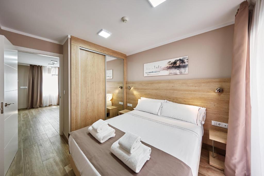 1 dormitorio con 1 cama con 2 toallas en GBH Hotel-Apartamentos Caballito de Mar, en Benidorm