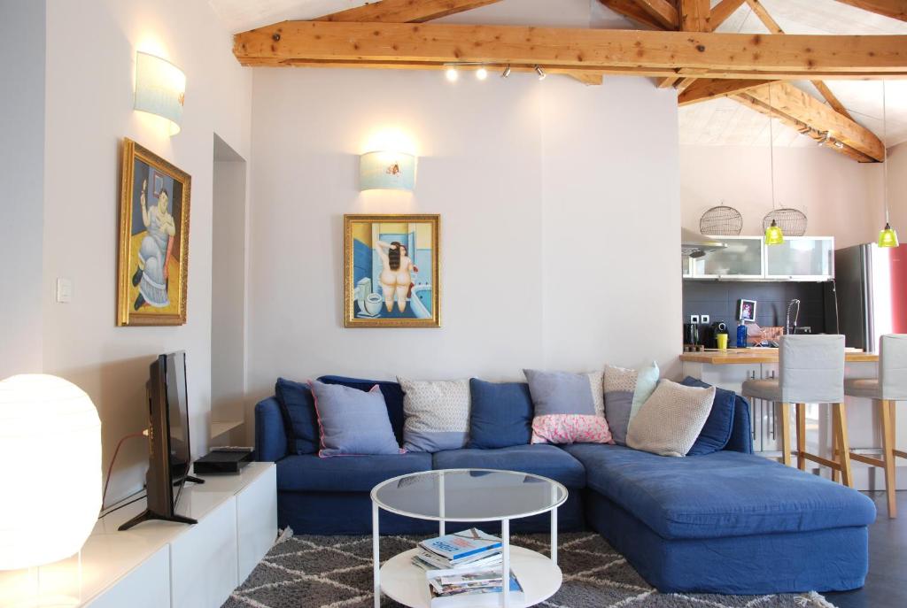 sala de estar con sofá azul y mesa en La Siesta en La Rochelle