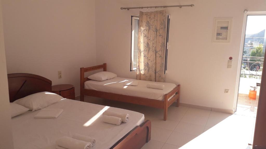 a room with two beds and a bathroom with a window at Rooms village center in (( Spile ))