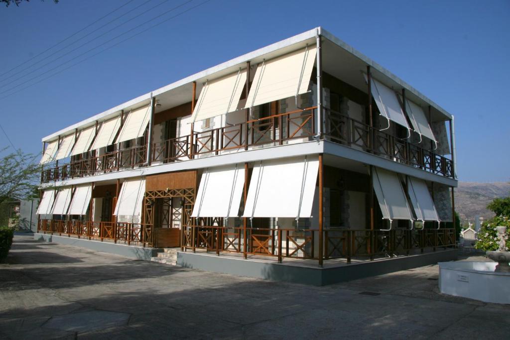 ein Gebäude mit Balkon auf der Seite in der Unterkunft Circe Pansion in Lixouri