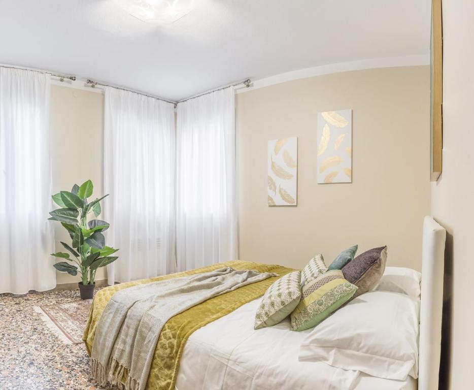 Un dormitorio con una cama con almohadas encima. en San Marco Square with Canal View by Wonderful Italy, en Venecia