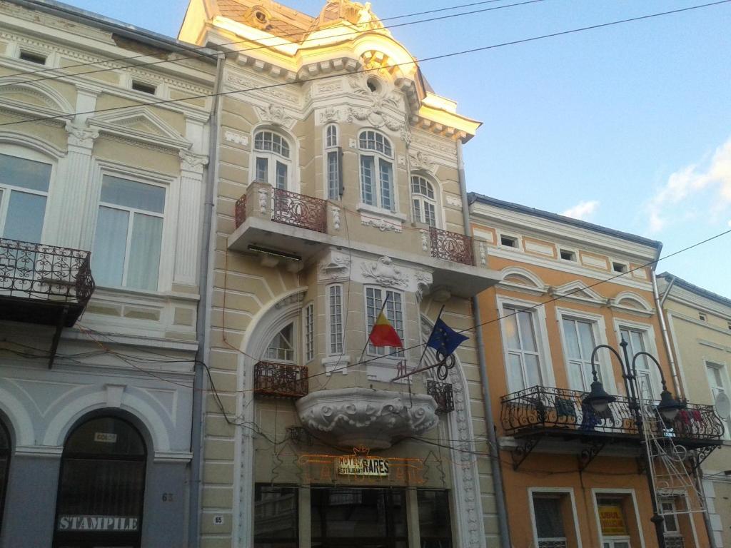 a large building with a flag on the side of it at Hotel Rares in Botoşani