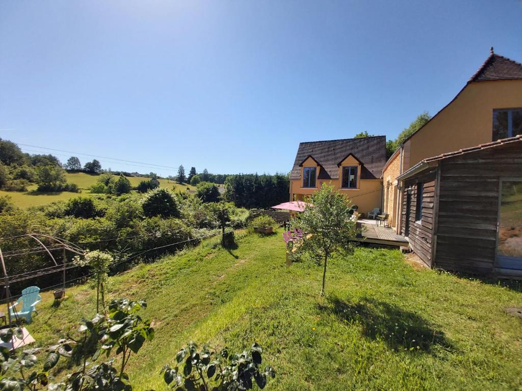 a house on the side of a hill with a yard at BonBon Chambre d'hôtes in Saint-Julien-de-Lampon