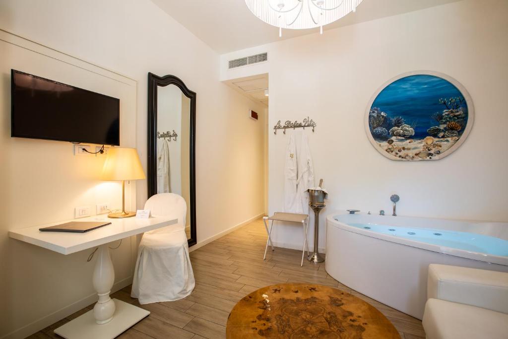 فندق Rimini Suite في ريميني: حمام أبيض مع حوض وطاولة ومكتب