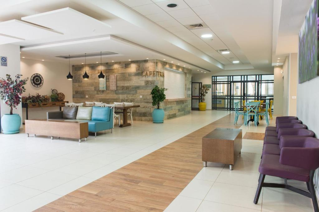 a lobby of a hospital with purple chairs and tables at HI - Tel Hai Hostel in Tel H̱ay