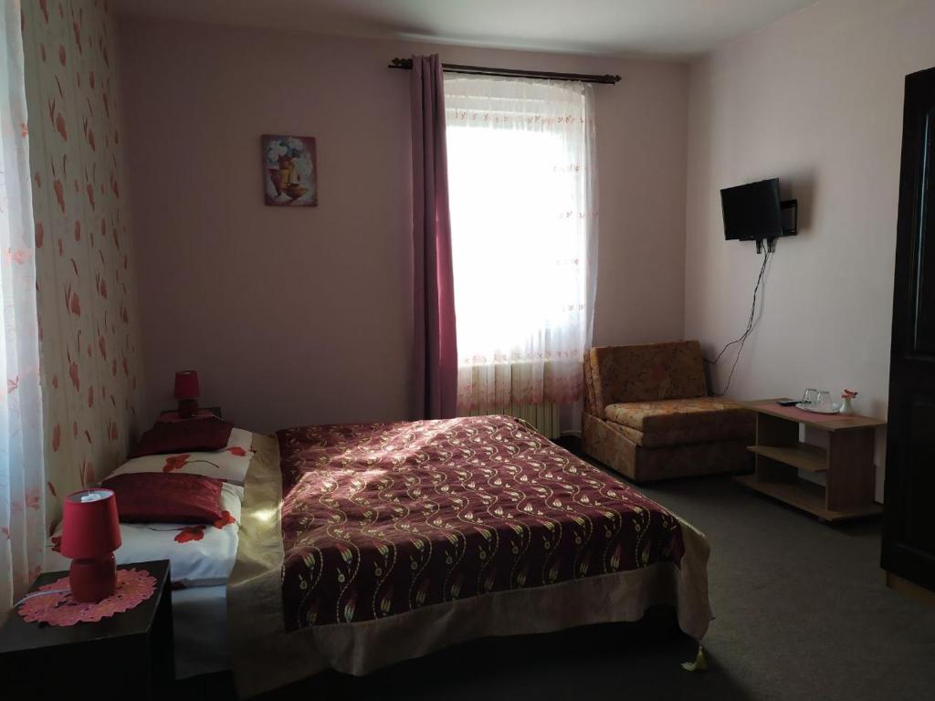 a bedroom with a bed and a chair and a window at Diamant in Karlovy Vary