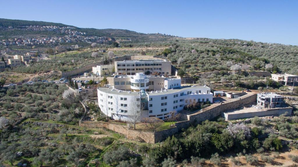 an aerial view of a large white building on a hill at HI - Pkiin Hostel in Buqei‘a