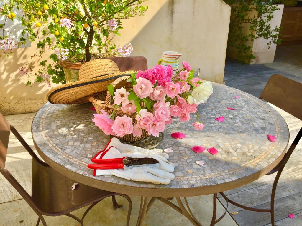 a glass table with flowers and a basket on it at La Villa ioanes in Port-Saint-Louis-du-Rhône