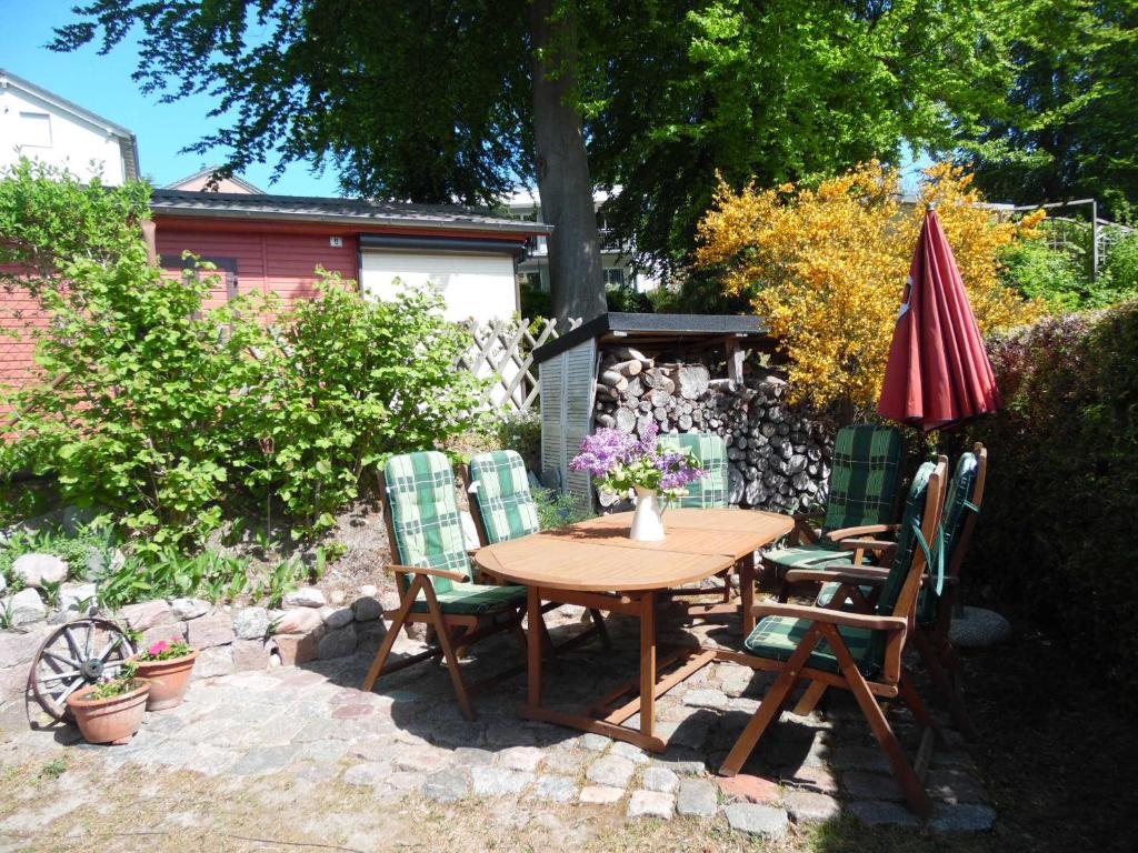オストゼーバート・ゼリンにあるFerienhaus Ostseefluesternの木製テーブル(椅子、傘付)