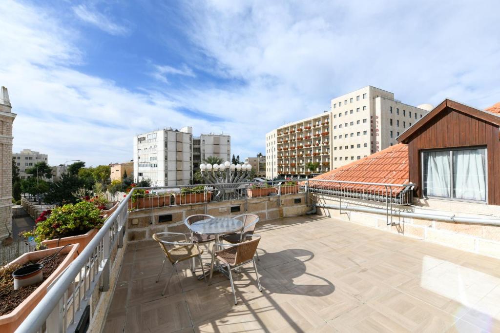 un balcone con tavolo e sedie su un edificio di HI Agron - Jerusalem Hostel a Gerusalemme