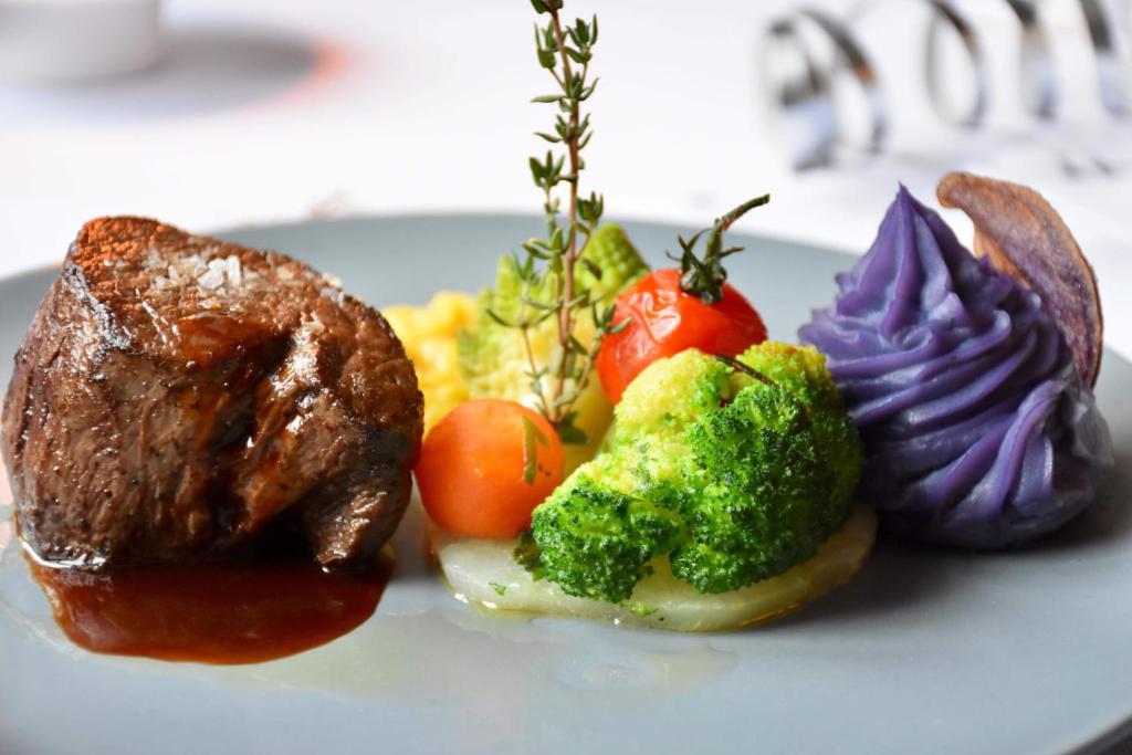 un piatto di cibo con carne e verdure sopra di Gasthaus Ochsen a Tägerwilen