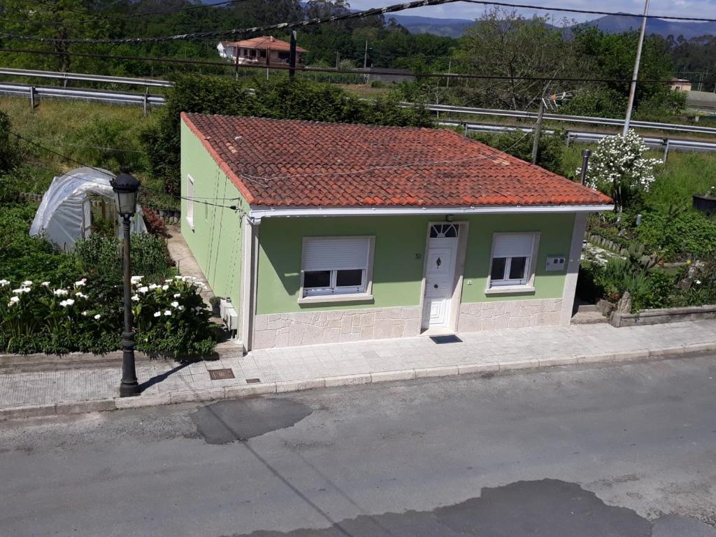 une petite maison verte avec un toit rouge dans l'établissement Casa IRIENSE VUT-CO-004308, à Padrón