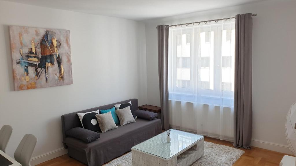 ein Wohnzimmer mit einem Sofa und einem Fenster in der Unterkunft Wonderful 2-Bedroom Belvedere Apartment in Wien