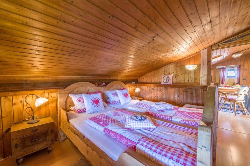 ein Schlafzimmer mit einem Bett in einer Holzhütte in der Unterkunft Direkt zwischen Chiemsee u Alpen Dg in Bernau am Chiemsee