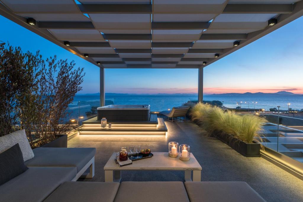 un patio con mesa y vistas al océano en Urban Suites, en Atenas