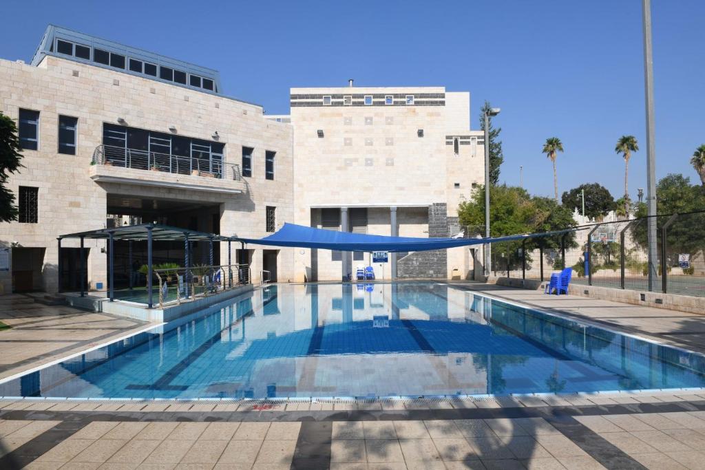 a large swimming pool in front of a building at HI - Beit Shean Hostel in Bet Sheʼan